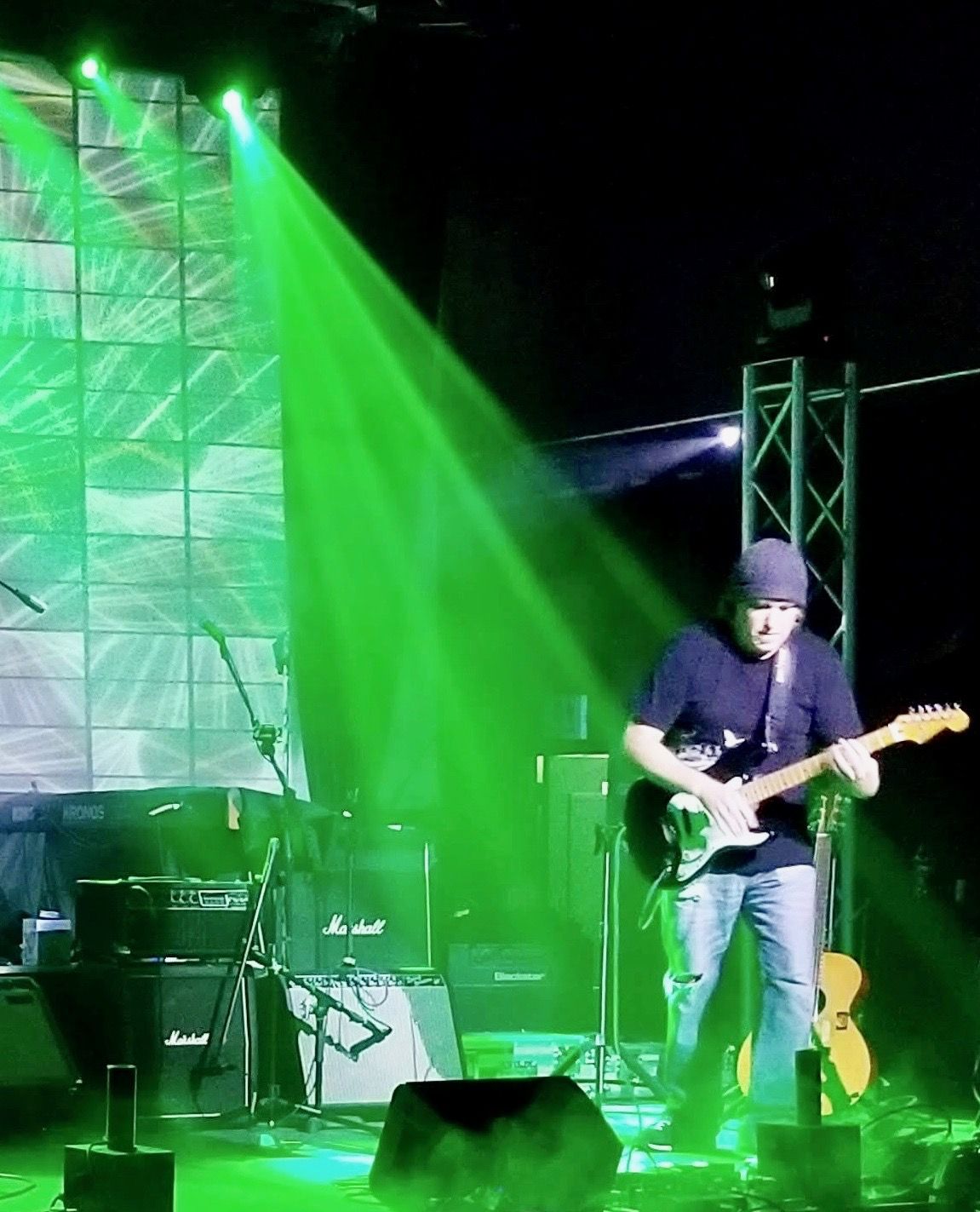 Under green light, in front of the Marshall stacks