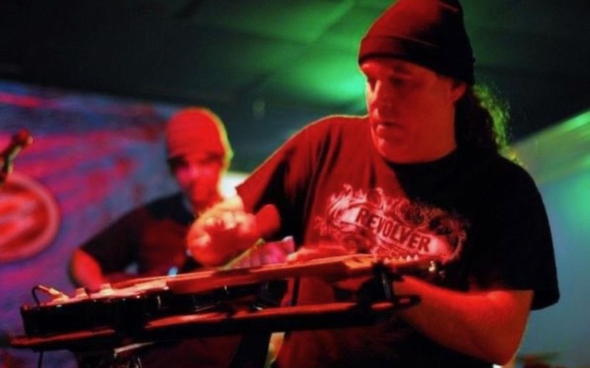 Lap steel under red light with the band